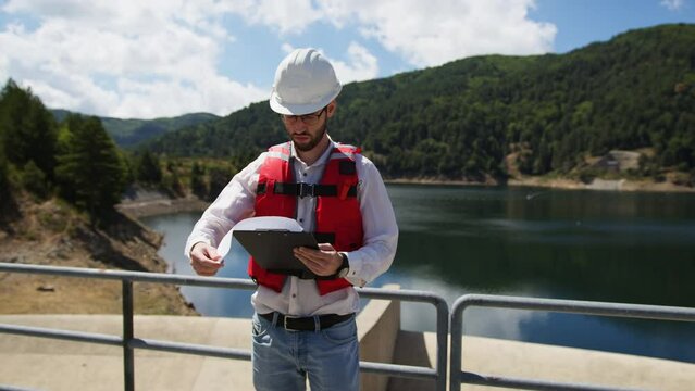 Engineer with white helmet check maintenance of the dam