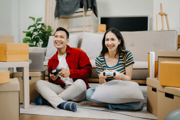 Asian young attractive couple man and woman use tablet and smartphone online shopping furniture decorate house with carton package move in new house. .