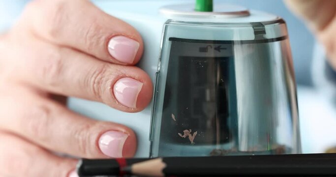 Womans hand sharpening pencil with electric sharpener 4k movie. Designer work concept
