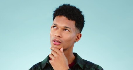 Thinking, idea and young man in a studio with dreaming, guess or question facial expression. Remember, reflection and model from Mexico with curious, solution or brainstorming face by blue background