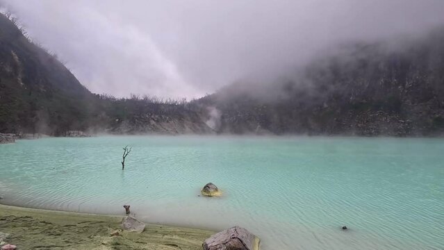 Kawah Putih or White Crater inside a volcanic crater in Ciwidey, West Java, Indonesia with a green sulfur lake.