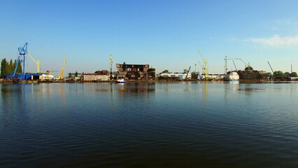 Fototapeta premium Flying Low Over Water Near Shipyard Construction Site