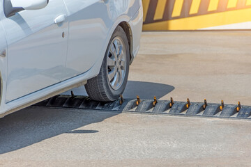 Spikes barrier are frequently used to enforce a directional flow in a single traffic lane. Car departing from the parking lot.