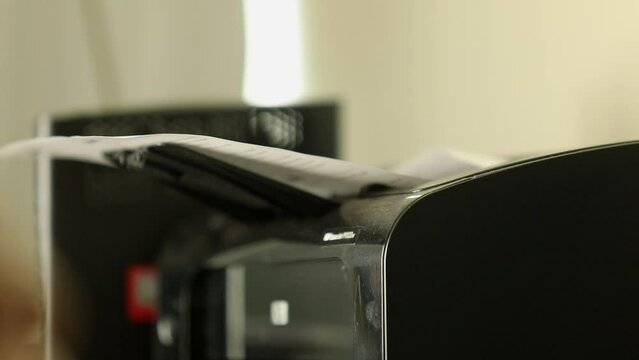 Documentation running through feeder tray of photocopier. Office equipment