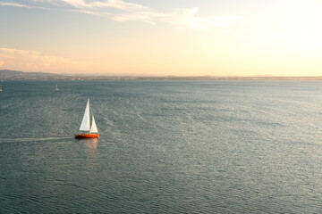 Solitary sailing boat on Lake Constance in Germany (Bodensee) sailing into the beautiful sunset