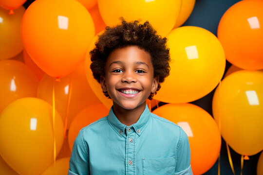 afroboy about 8 years old smiling. professional studio photography. ballons background