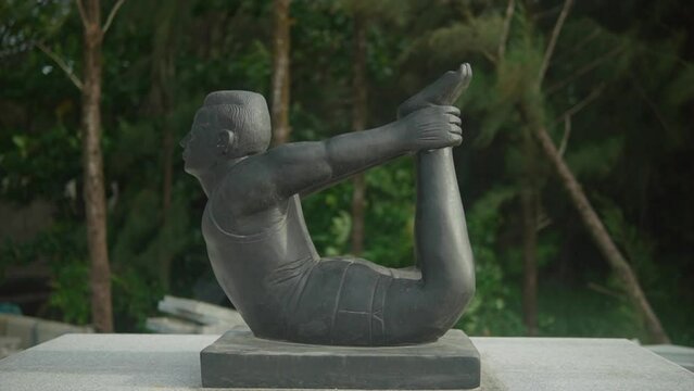 Statue of a Man holding his Feets in Dhanurasana Yoga Posture