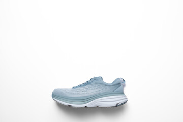 New light blue green female modern running shoe on white background. Stylish monochrome shoes for active people that incorporate new health technology. Side view