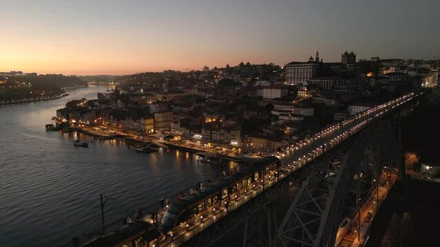 Aerial view of train crossing the historic Dom Luis I Bridge over the Douro River at dusk in Porto (Oporto), Portugal.