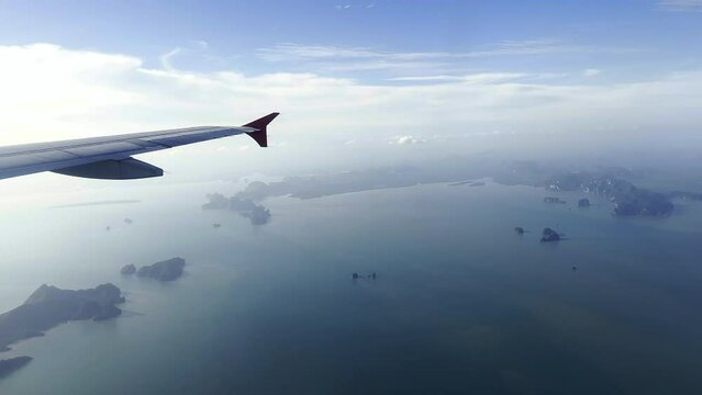 Flying over Islands. View from plane window. Flying over calm seas. Phuket, Thailand.