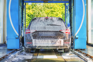 Car in soapy foam is in the car wash