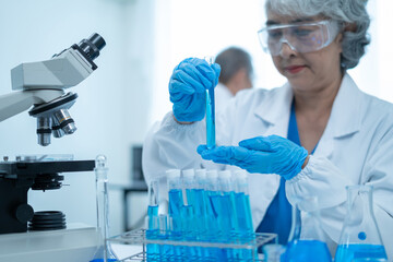 Scientist mixing chemical liquids in the chemistry lab. Researcher working in the chemical laboratory.