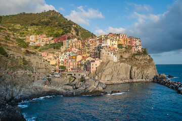 Fototapeta na wymiar Manarola beach and colorful architecture on cliff, famous Cinque Terre commune, ITALY
