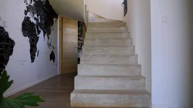 Slow tilting shot revealing a stone villa staircase with vertical wooden paneling