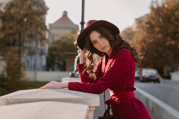 beautiful stylish woman in purple suit and hat walking in city street