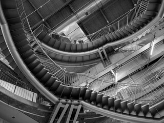 Large circular stairs leading up inside a multi-story building (monochrome)