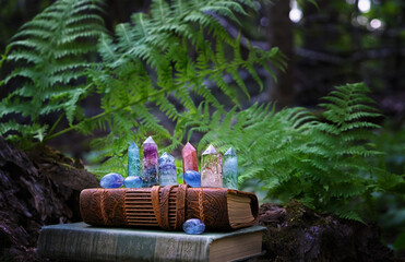 old witch spell books and quartz minerals in forest, natural background. Gemstones for Magic...