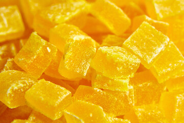 Diced mango dried fruits texture background. Dehydrated mango chips dices, sweet food closeup