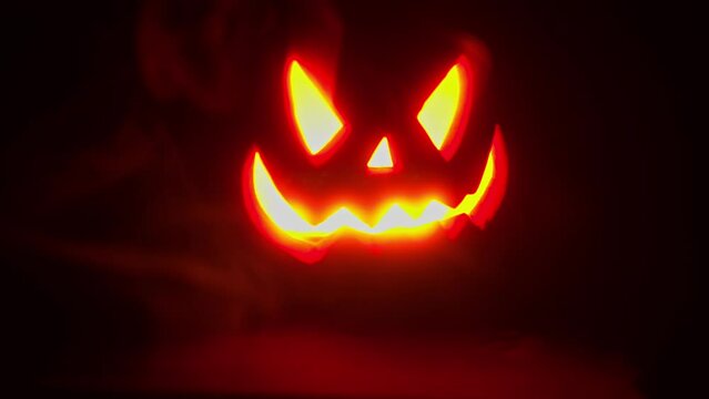 Jack O Lantern glowing on a black background, smokey hazey 4k Halloween or horror asset or background