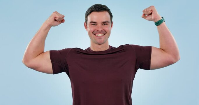 Man, champion and flexing biceps with fitness, strong athlete and face on blue background. Workout, muscle and power, fight and happy in portrait with exercise in gym, health and wellness in studio