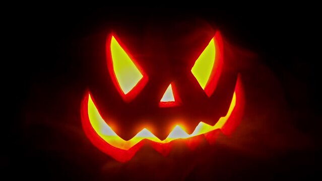 Jack O Lantern glowing on a black background, smokey hazey 4k Halloween or horror asset or background