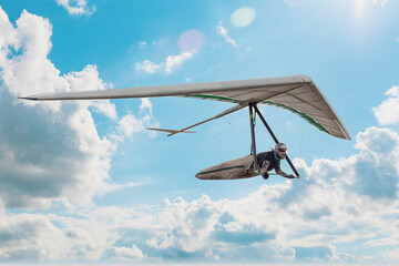 Hang glider pilot soar in the blue sky - 648086906