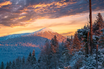 Snowy mountain peak and sunset sky.