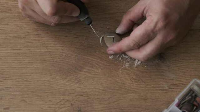 a man carves runes out of stone