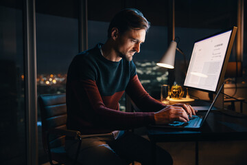 Business man working late hours in his office, completing a digital marketing project