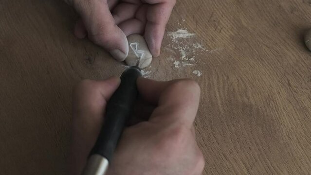 a man carves runes out of stone