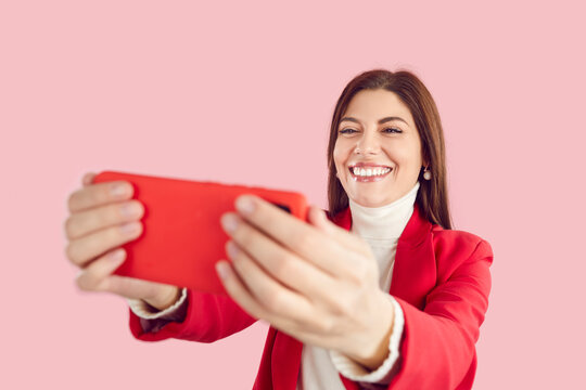 Free Photo  Happy beautiful girl playing mobile video game, holding  smartphone horizontally, watching on cellphone with excited face, pink  background.