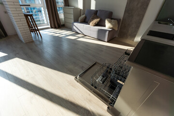 Open dishwasher with clean dishes in the white kitchen.