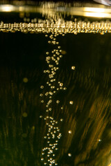 Glass of french sparkling champagne wine with bubbles on dark background, bubbles close up