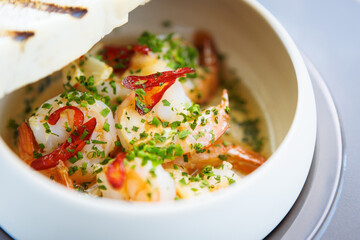 Shrimp pil-pil. King prawns, garlic, chilli and baguette. Delicious Spanish traditional food closeup served for lunch in modern gourmet cuisine restaurant - 648110910