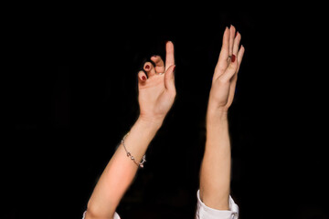 Fototapeta premium Women's hands up gesture of a girl's hand while dancing on a black background