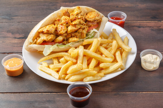 Doner kebab sandwich sur une assiette avec des frites et sauces. Sp&eacute;cialit&eacute; culinaire turque. Restauration rapide.