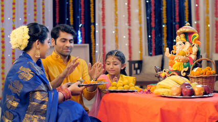 Loving Indian family worshipping Lord Ganesha with pooja ki thali  a festival celebration  Ganesh...