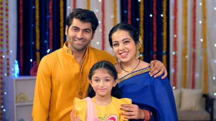 A cute little girl with her parents in the living room - Diwali celebrations  family bonding ...