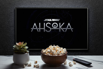Obraz premium Ahsoka trailer or movie on TV screen. TV with remote control, popcorn bowl and home plant. Astana, Kazakhstan - September 8, 2023.