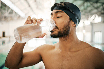 Man, swimmer and drinking water for hydration, exercise or training workout at indoor swimming...
