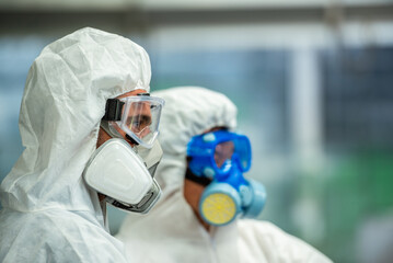 Male inspector team investigate danger chemical gas leak spill with safety face mask PPE suit in...