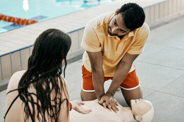 Swimming pool safety, first aid and man teaching life saving process rescue support or helping with danger. Client, emergency CPR and person learning medical service, lifeguard or practice on dummy