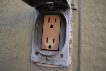 Dirty Old Outlet with Weather Cover on Outside Wall of Garage