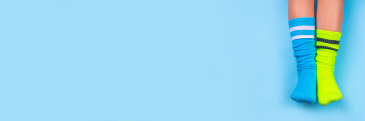 Odd Socks Day, Lonely Sock Day.  Anti-Bullying Week, Down syndrome awareness. Child legs wearing different pair of mismatched socks on high-colored background copy space