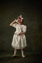 Portrait of elegant little girl drinking tea over vintage background. Fairy princess character of...