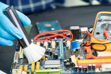 Asian technician repair and cleaning dirty micro circuit main board of smartphone electronic...