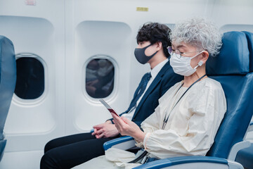 飛行機で旅行をする高齢の女性
