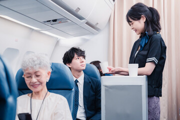 機内で飲み物の提供をするキャビンアテンダント