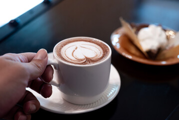 hand and a white cup hot chocolate, woman Hand hold cup of hot chocolate cocoa drink