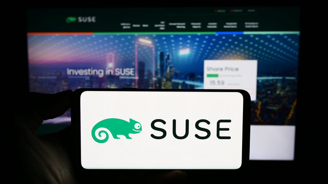 Stuttgart, Germany - 09-10-2023: Person holding smartphone with logo of open-source software company SUSE S.A. on screen in front of website. Focus on phone display.